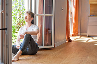 Junger Mann sitzt im Fenster