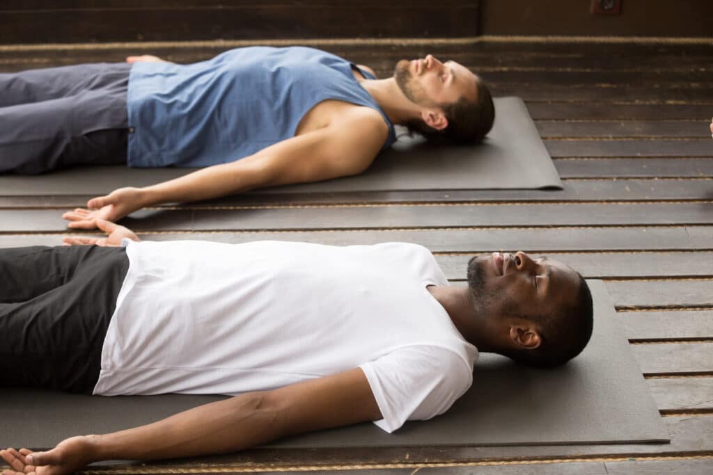 Zwei Männer liegend in Meditation